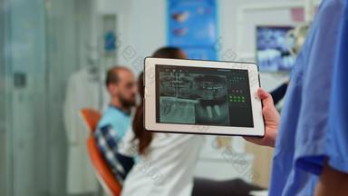 关闭牙医护士持有平板电脑数字射线照相法